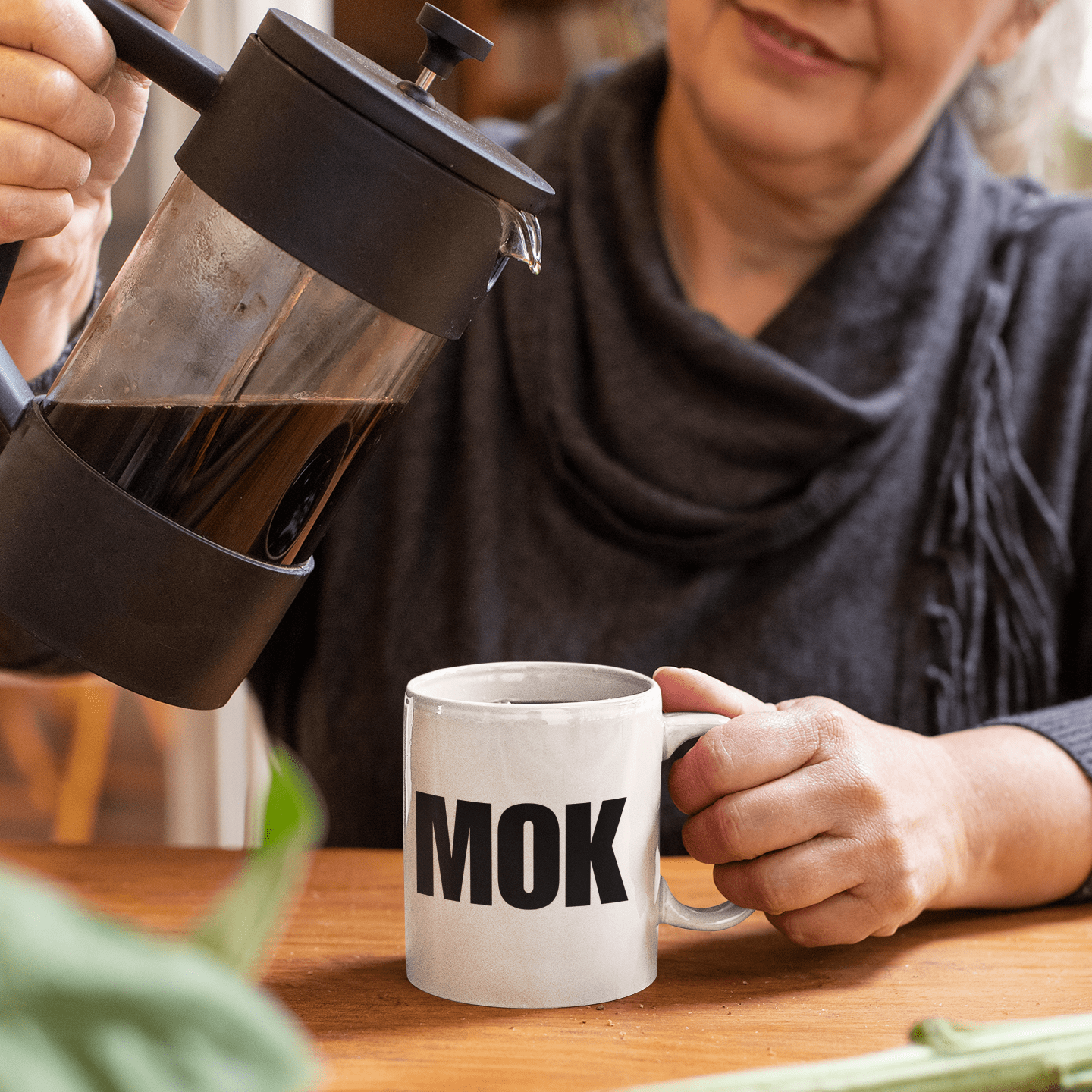 MOK MOK sfeerfoto van oude vrouw die de mok inschenkt met koffie
